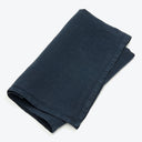 Neatly folded dark blue fabric, potential large tablecloth or fabric.