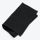 Neatly folded black fabric, possibly denim, against a white background.