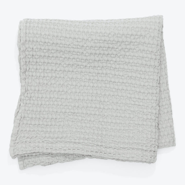 Folded gray blanket with textured design, exuding warmth and comfort.