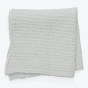 Folded gray blanket with textured design, exuding warmth and comfort.
