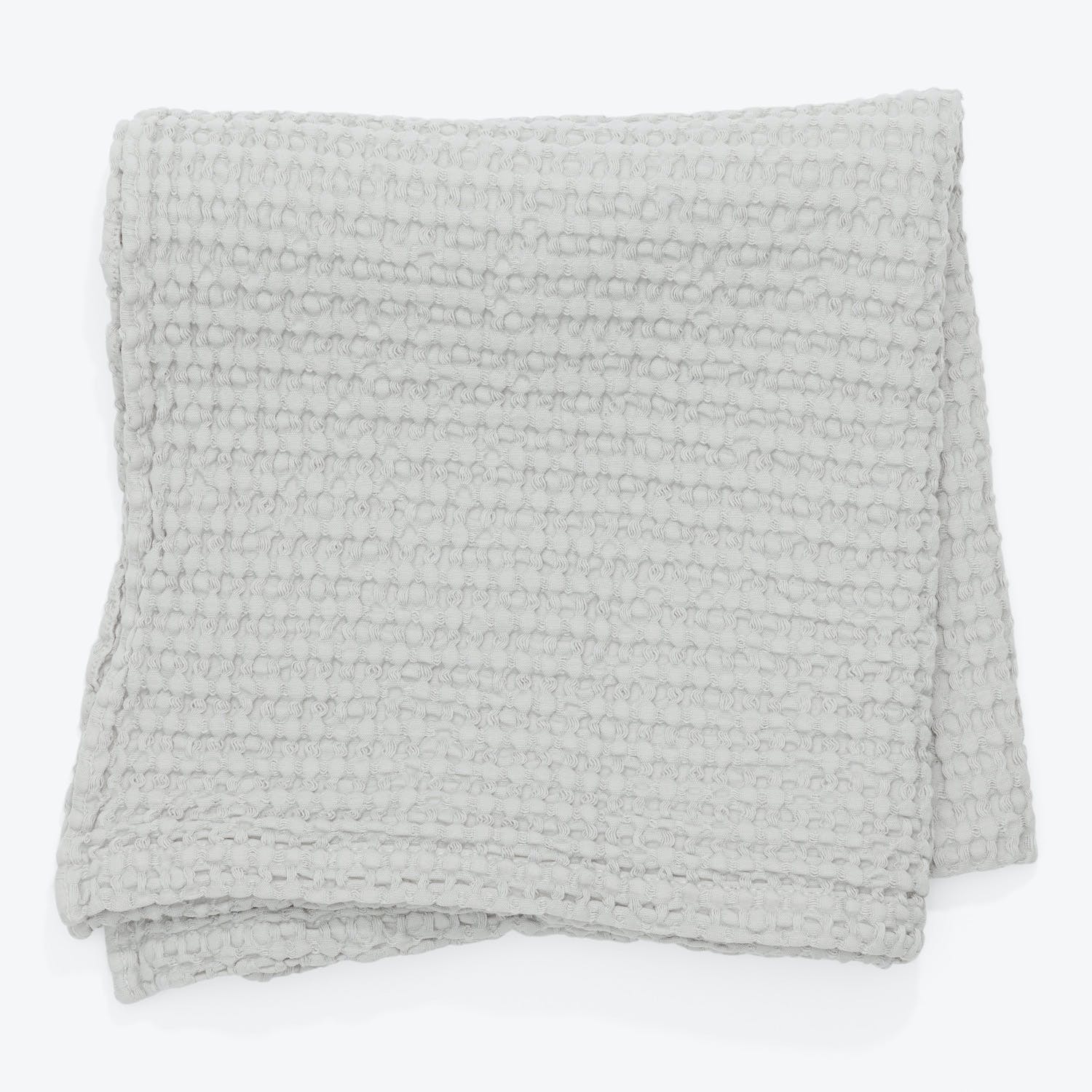 Folded gray blanket with textured design, exuding warmth and comfort.