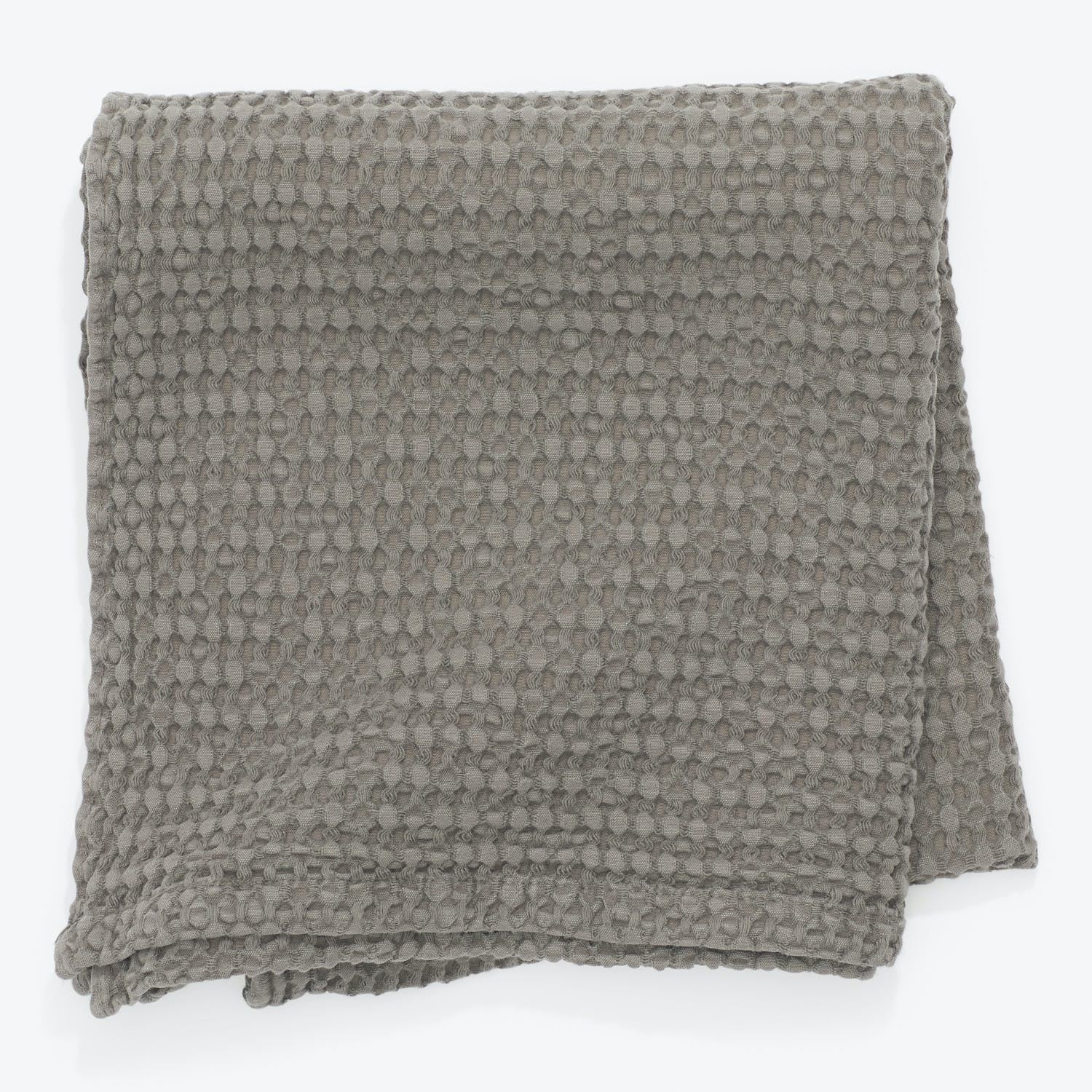 Gray textured throw with raised circular patterns adds cozy charm.