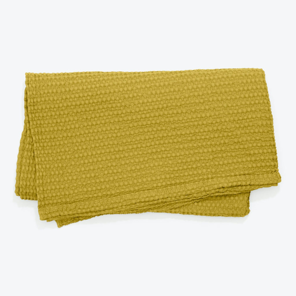 Vibrant yellow-green plush throw adds cozy charm to any room.