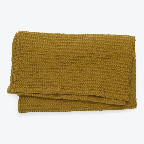 Mustard-yellow textured blanket with waffle knit pattern for extra warmth.