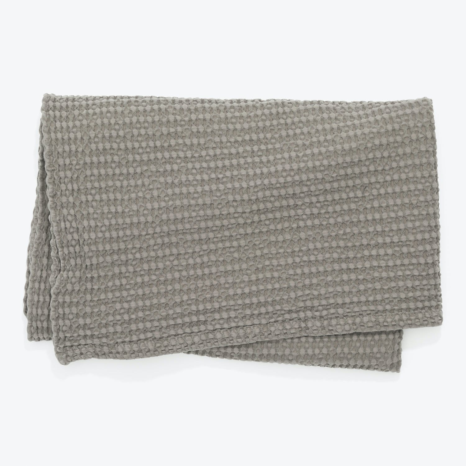 Cozy and stylish, a folded gray blanket with waffle texture.