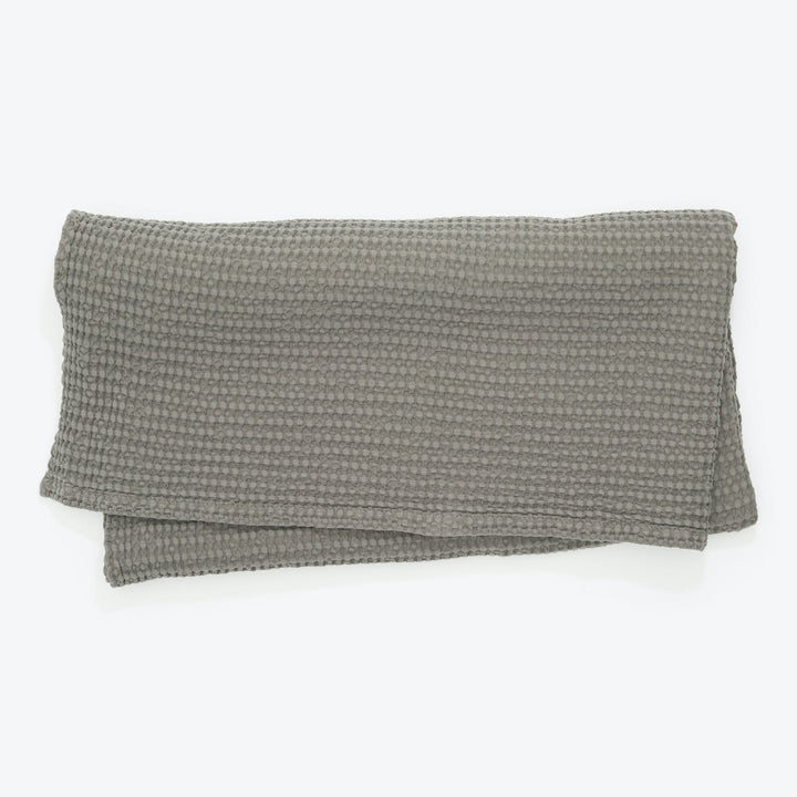 Rectangular grey pillow cover with waffle-like texture on white background.