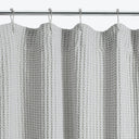 Close-up view of a textured curtain with pom-pom design.