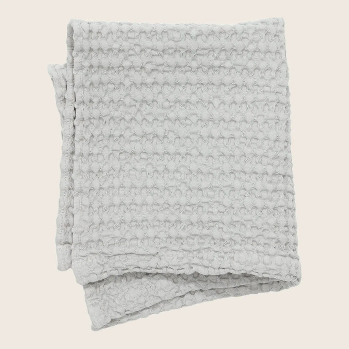 Folded gray blanket with plush ripple design, neatly displayed.