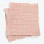 A soft and cozy light pink blanket with a textured pattern.