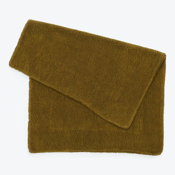 Plush olive green towel elegantly folded, perfect for linen closets.
