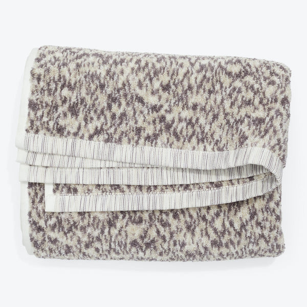 Soft and fluffy beige and brown towel with decorative patterning.