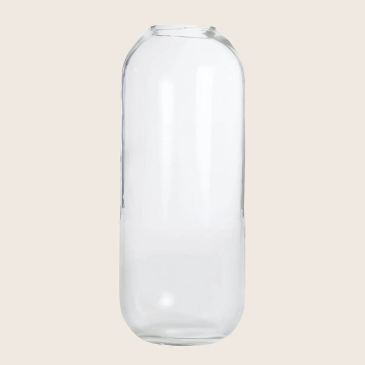 Empty clear glass bottle with smooth surfaces and cylindrical shape.