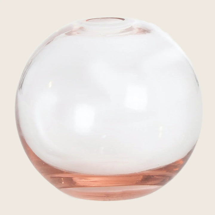 A transparent glass sphere with a pinkish hue at the base.