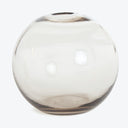 Round, transparent glass vase with smoky tint and reflective surface.