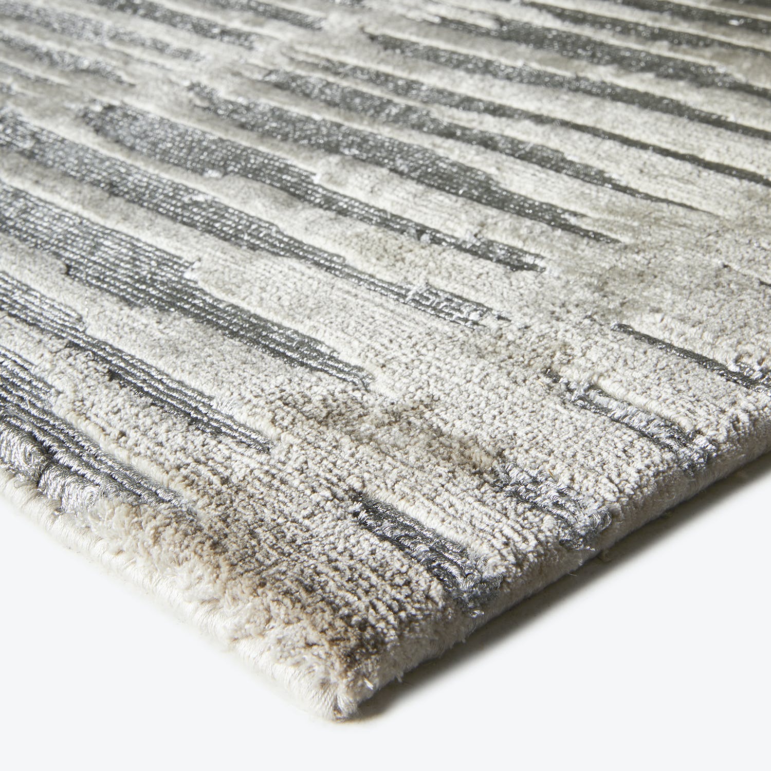 Textured rug with alternating high and low pile creates stripes.