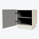 Modern beige storage cabinet with one open door and shelf.