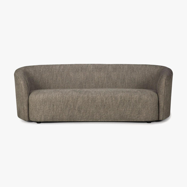 Modern curved sofa with neutral upholstery and minimalist silhouette.