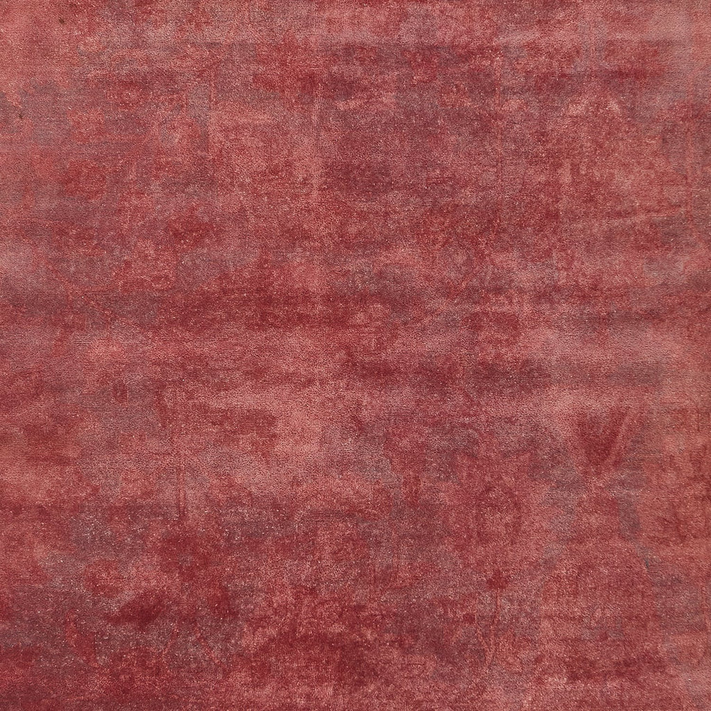 Close-up of faded red texture with mottled distressed appearance.