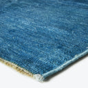 Close-up of a worn blue woven rug with visible textures.