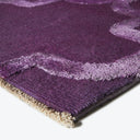 Close-up of a plush purple rug with abstract geometric pattern.