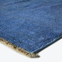 Close-up of a dense, uniform blue rug with fraying edges.