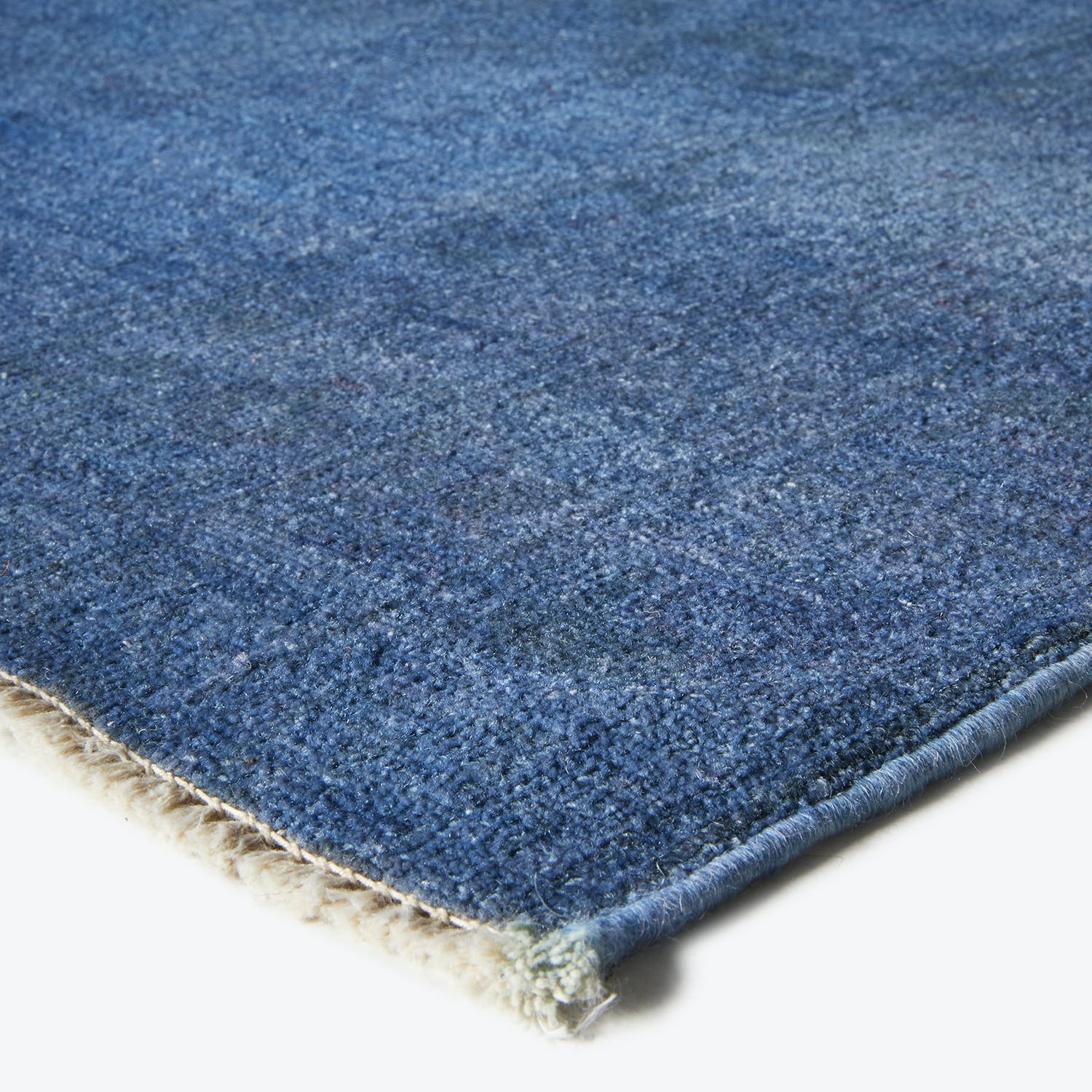 Close-up of a plush, high-quality blue carpet with textured fibers.