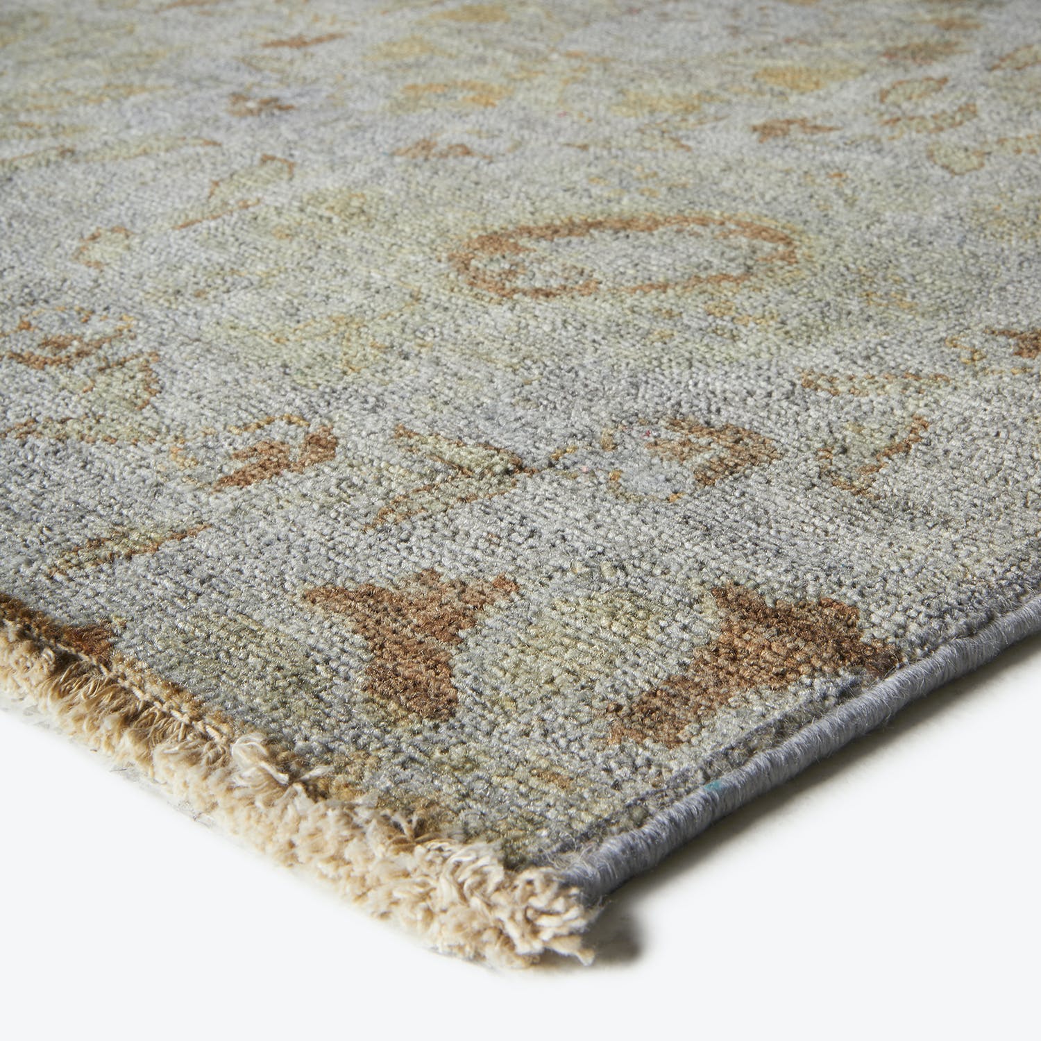 Close-up view of a textured rug with cool grey tones.