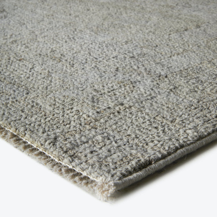 Close-up of a loop pile carpet with uniform light gray color.