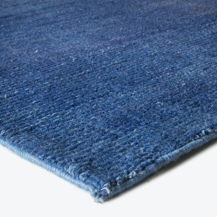 Close-up view of a soft and reflective blue carpet.