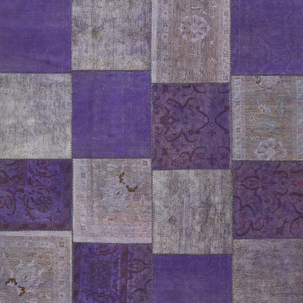 Purple patchwork quilt featuring intricate floral and paisley designs.