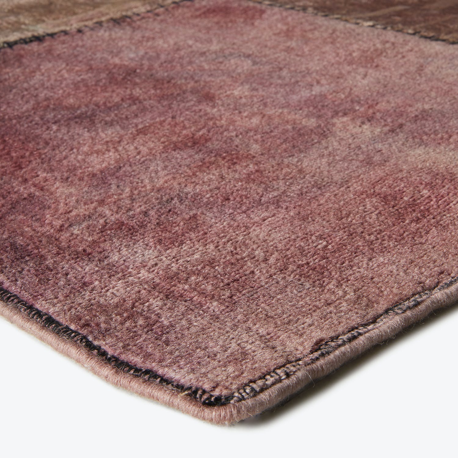 Close-up of a plush, ombré rug with bound edges.