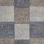 Patchwork carpet with traditional motifs in muted colors and visible stitching.