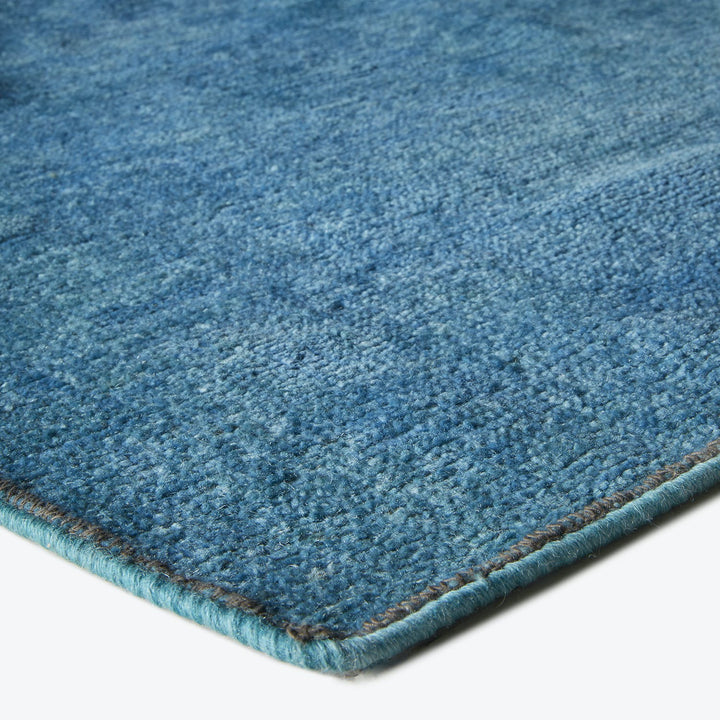 Close-up view of a plush blue carpet with visible texture.