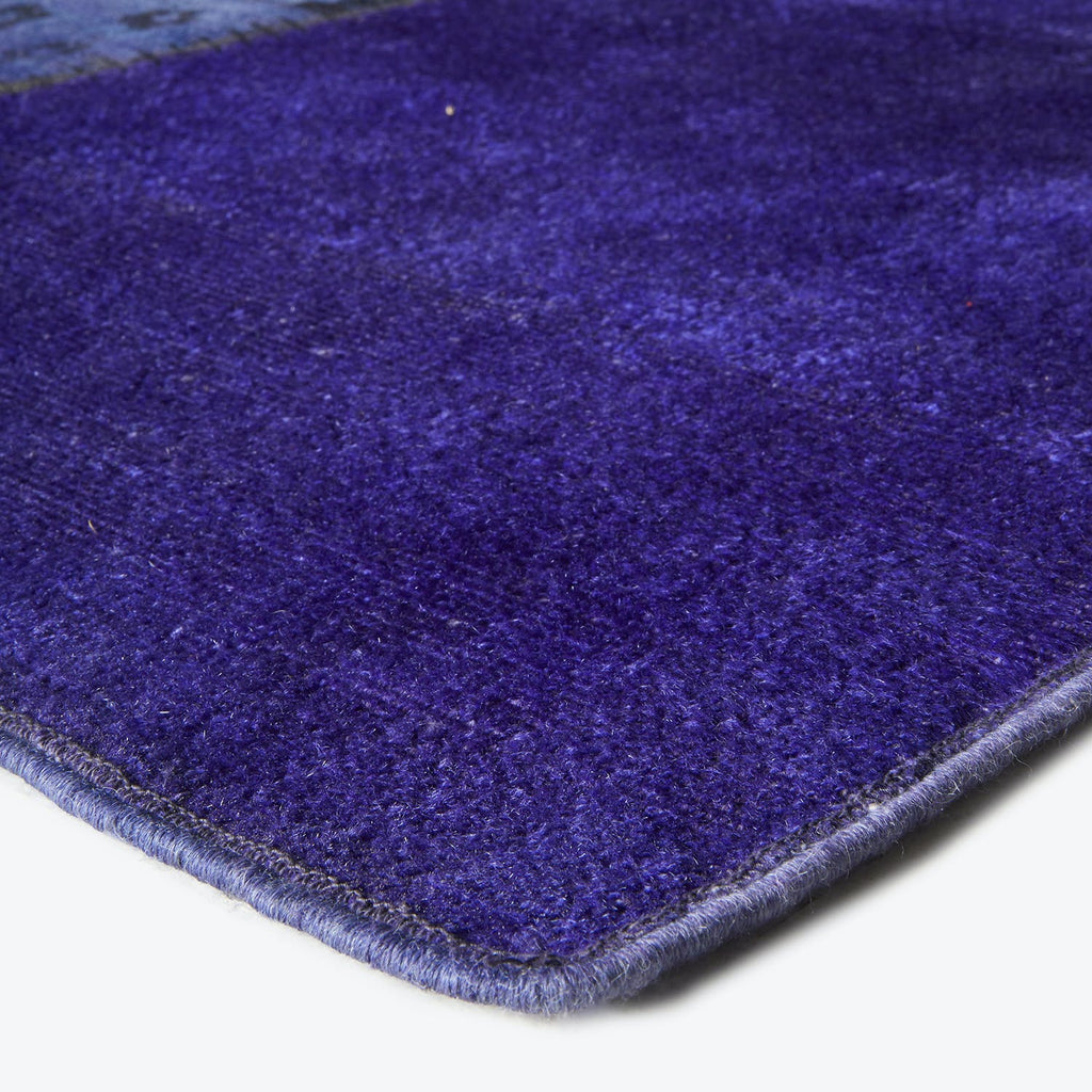 Close-up of a deep blue or purple plush carpet texture.
