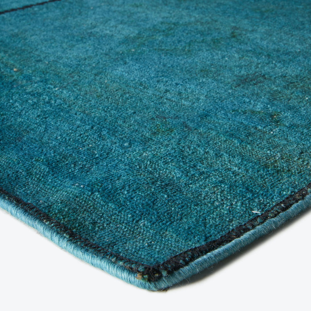 Close-up view of a rich blue rug with textured appearance.