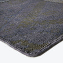 Close-up of a blue and green textured carpet with wear.