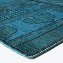 Vibrant turquoise textile showcases intricate patterns and plush texture.