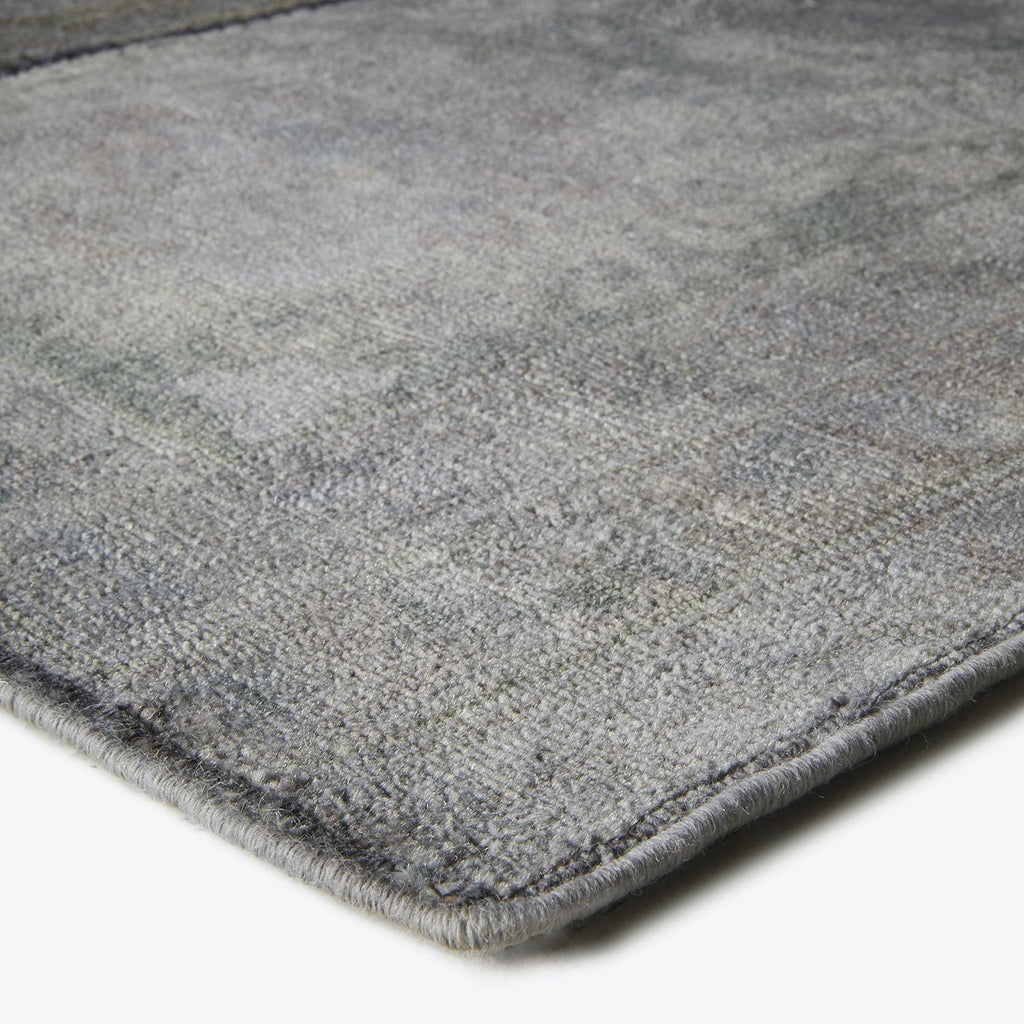 Close-up view of a plush, textured rug in muted greys.