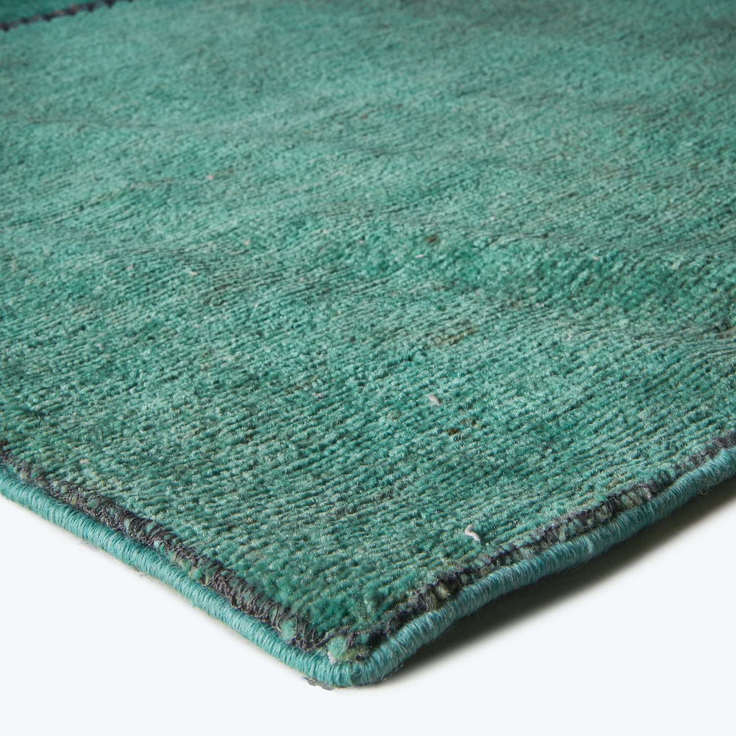 Close-up of a green carpet with visible textured fibers.