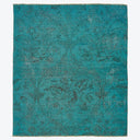 Intricate floral pattern in teal fabric with textured woven design.