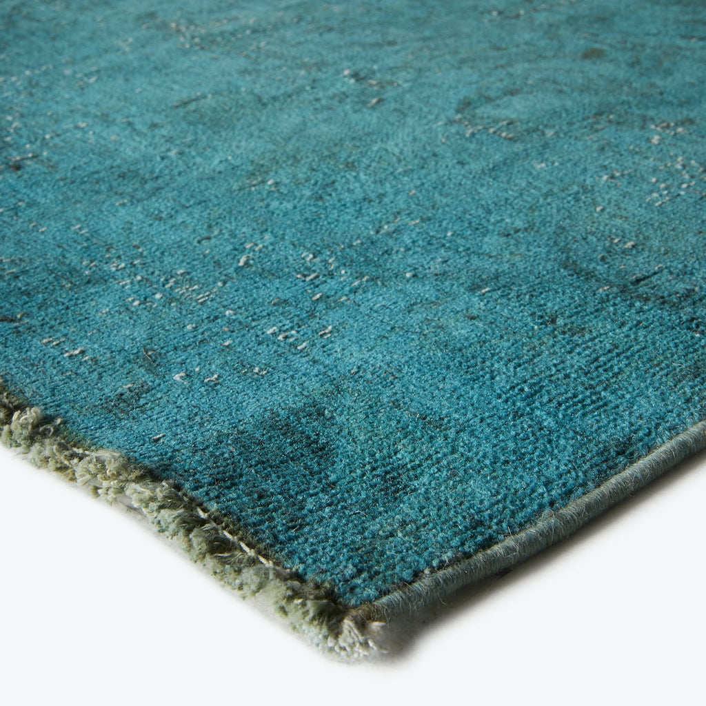 Close-up view of a rich turquoise carpet with plush texture