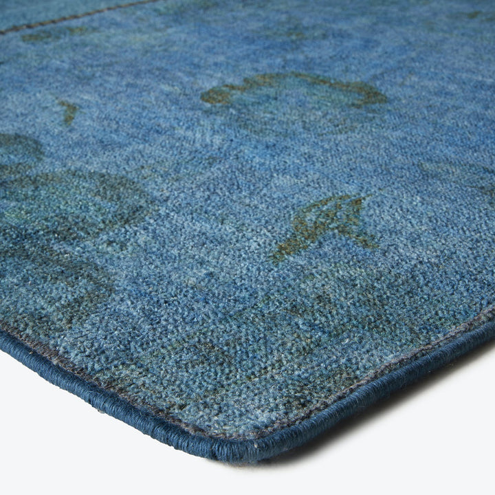 Close-up of a plush blue rug with abstract patterns.