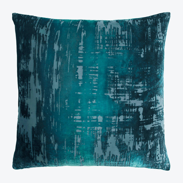 Abstract teal square pillow with textured distressed surface design.