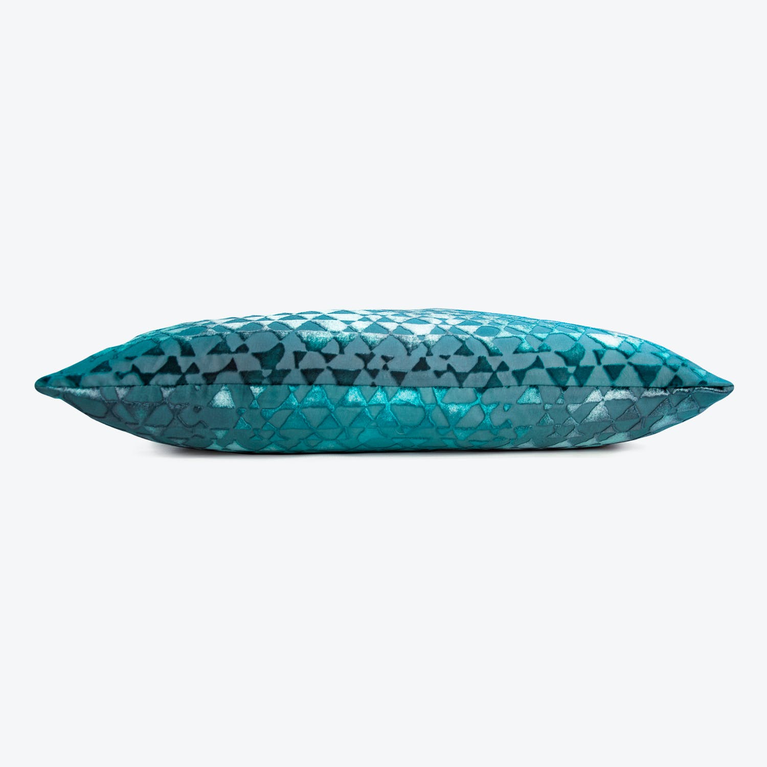 Vibrant teal and blue geometric patterned pillow adds decorative flair.
