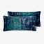 Abstract teal pillows with distressed white pattern on neutral background.