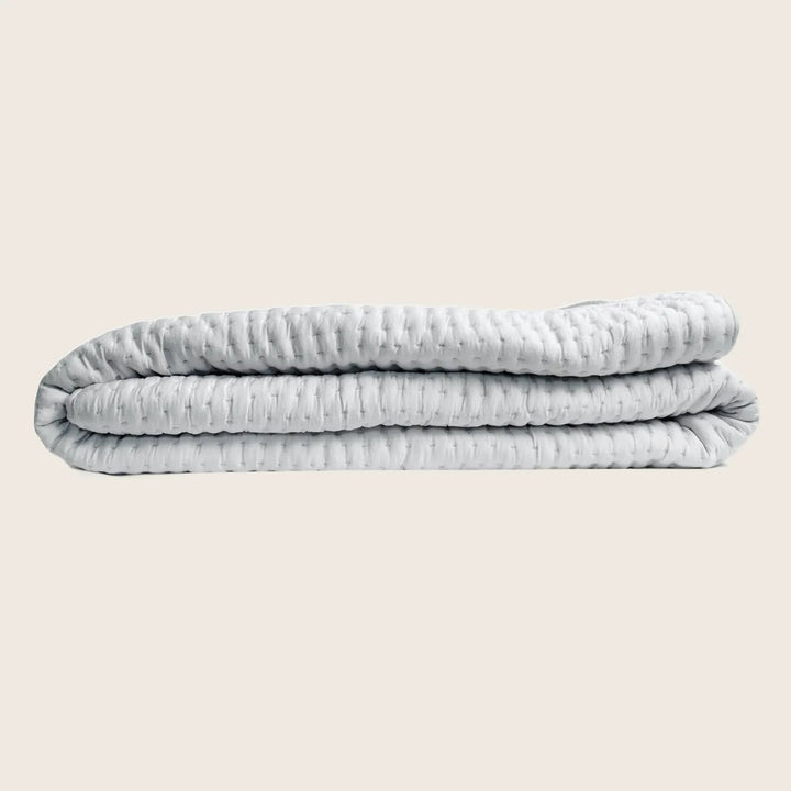 Neatly folded, evenly distributed, and comforting weighted blanket in light-grey.