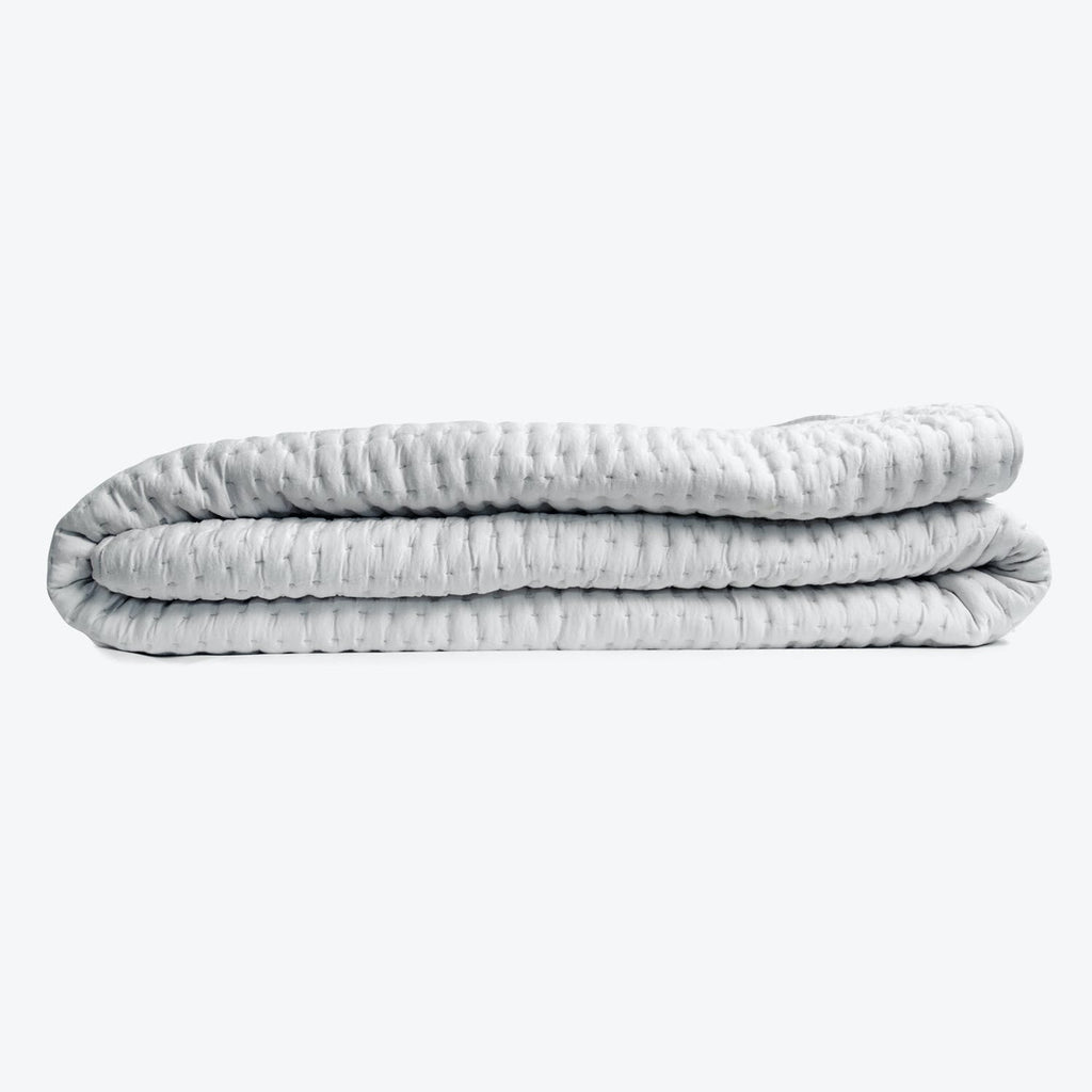 Neatly folded, evenly distributed, and comforting weighted blanket in light-grey.