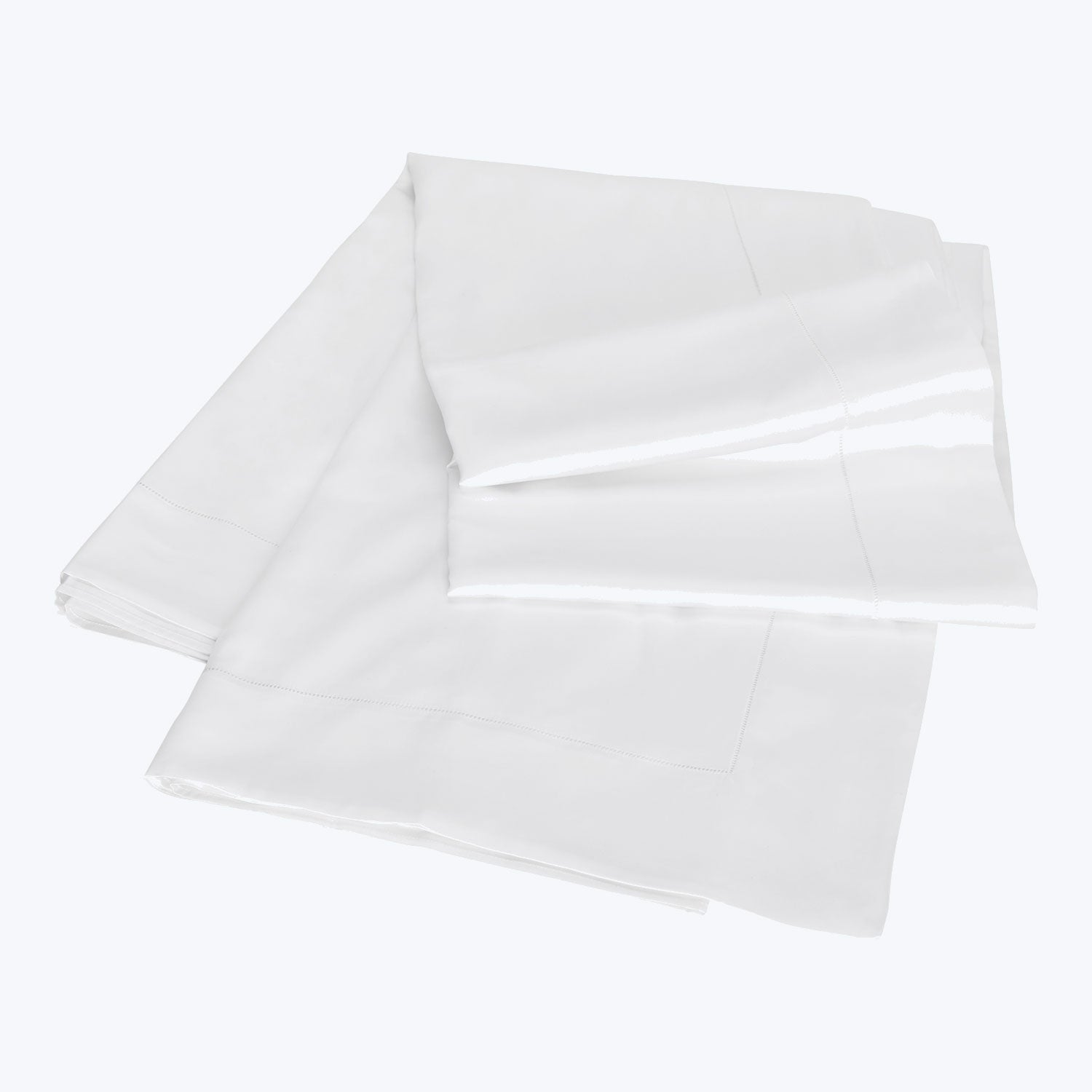 Simple and versatile white bed linens neatly folded and soft.