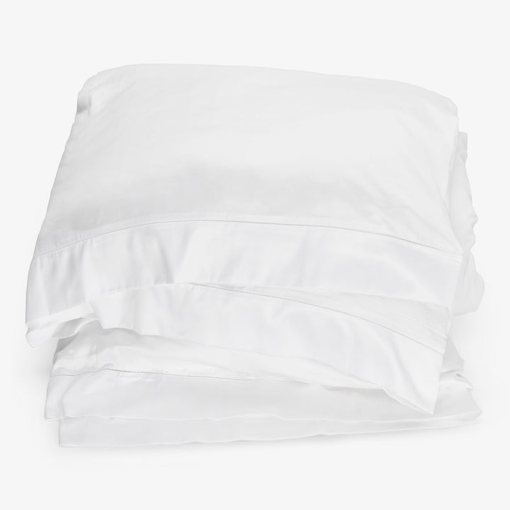 Neatly folded, crisp white bed linen exudes comfort and luxury.