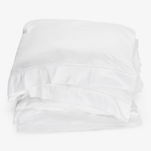 Neatly folded, crisp white bed linen exudes comfort and luxury.